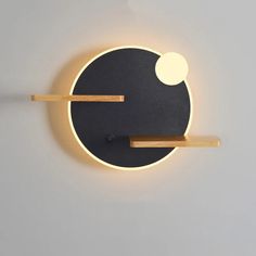 a black and white clock with two wooden sticks sticking out of it's face