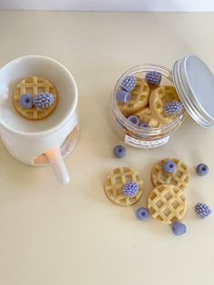 some waffles and blueberries are sitting on a table next to a cup