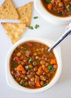 a bowl of slow cooker lentil soup with tortilla chips on the side