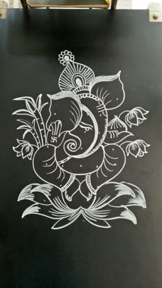 an elephant is painted on the side of a black board with white paint and flowers