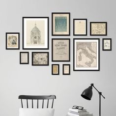 a white chair sitting in front of a wall filled with pictures and framed art on it