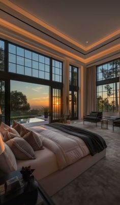 a bedroom with large windows overlooking the sunset