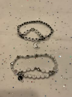 "Matching set of bracelets with the lyrics \"to the moon and to Saturn\" on them. Can be made to a certain length with stretchable string. The current charms are seen in the second picture. The bracelet can be done in gold or silver with the planet either being black or white. Please note that these bracelets will be made to order." Love You To The Moon And To Saturn Bracelet, To The Moon And To Saturn Bracelet, Exile Bracelet Taylor Swift, Moon And Saturn Bracelet, Tiny Bead Bracelet Patterns, Beaded Bracelets Friendship, Friendship Bracelets With Charms, Matching Friendship Bracelets Beaded, Cute Bracelet Ideas Bead