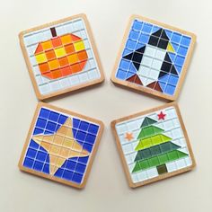 four pieces of colorful mosaic tile with an apple, star, and christmas tree on them