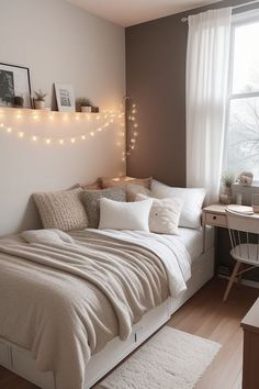 a white bed sitting under a window next to a desk