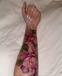 a woman's arm with flowers painted on it