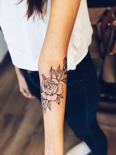 a woman with a rose tattoo on her arm