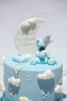 a blue cake decorated with clouds and a baby's pacifier