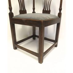 an old wooden chair with grey upholstered seat and backrests on a white background