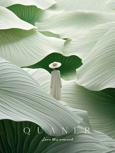 a woman standing in front of large green leaves