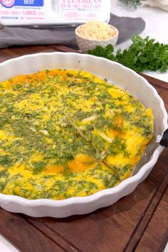 a casserole dish with spinach and cheese in it on a cutting board