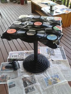 a table that has some records on top of it with newspaper and magazines around it