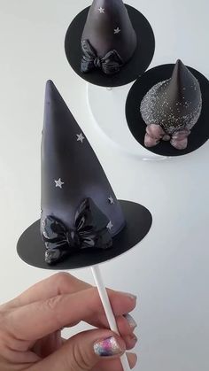 three witches hats on top of black plates with silver glitters and bowknots