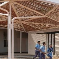 three men are walking under a wooden structure