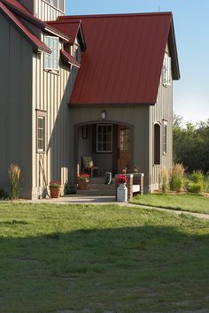 a large gray barn with a red roof