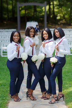 four beautiful women standing next to each other in front of an outdoor wedding ceremony area