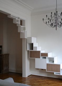 a living room with a chandelier hanging from the ceiling and shelves on the wall