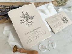 the wedding stationery is laid out on top of some paper and other crafting supplies