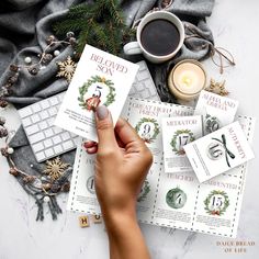 a person is writing on some cards next to a cup of coffee and a keyboard