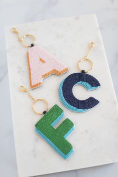 three key chains with the letter e, c, and f on them sitting next to each other