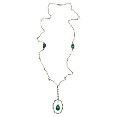 A sublime Antique Art Deco Pearl Lariat dating to the 1920s and the flapper era. A fancy bar link chain embellished with pearls sets the scene. Emerald paste adorns the chain in white settings in step with the white metal pendant within which a whole teardrop of glass jade is suspended. We love the way this piece emulates fine jewels of the period where yellow and white gold or platinum were used together. A beautiful and timeless find that will radiate elegance and style for the next 100 years. Luxury Art Nouveau Formal Necklaces, Luxury Art Nouveau Formal Necklace, Fancy Bar, Luxury Art Deco Collectible Necklaces, Luxury Art Nouveau Necklace With Intricate Design, Flapper Era, Luxury Art Nouveau Pearl Pendant Necklace, Pearl Lariat, Pearl Set