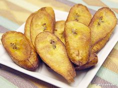 some fried bananas on a white plate on a table