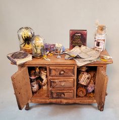 an old wooden desk with many items on it and some books sitting on top of it