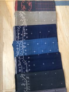 six different colored ties laid out on a table top with one being folded up and the other is laying down