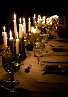 a long table with candles and wine glasses on it