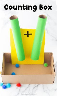 an open cardboard box with some green and yellow items in it on a marble surface