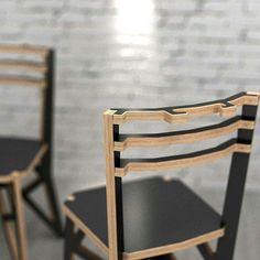 two black chairs sitting next to each other in front of a brick wall and floor