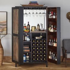 an open cabinet with wine glasses and liquor bottles on it in a living room area