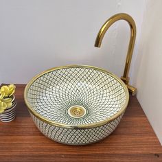 a bathroom sink sitting on top of a wooden counter next to a potted plant