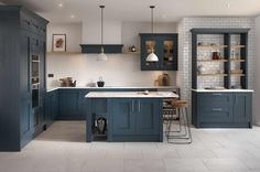 a large kitchen with blue cabinets and white tile flooring is pictured in this image