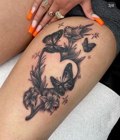 a woman's thigh with butterflies and stars on it