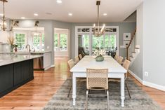 a dining room table and chairs in front of a kitchen with an open floor plan