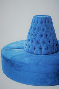 a blue round couch sitting on top of a white floor