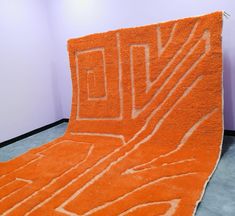 an orange rug is on the floor in front of a white wall and purple walls