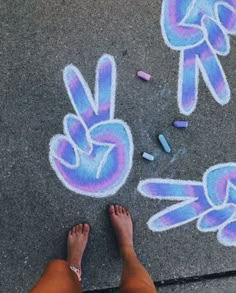 someone is standing on the sidewalk with their feet in front of some chalk drawings and crayons