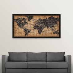 a living room with a gray couch and a large map on the wall above it