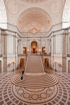 the inside of a large building with stairs and chandeliers on either side of it