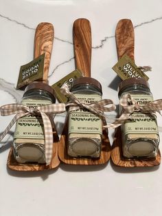 three wooden spoons and two jars with labels on them