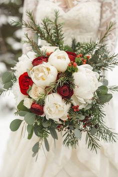 a bridal holding a bouquet of white and red flowers