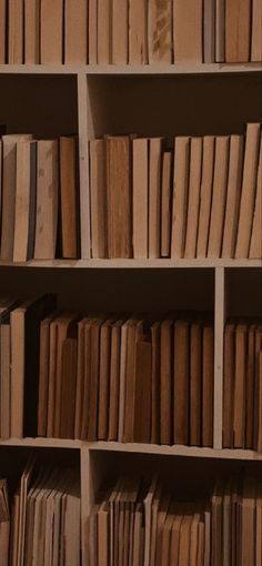 a book shelf filled with lots of books on top of wooden shelves next to each other