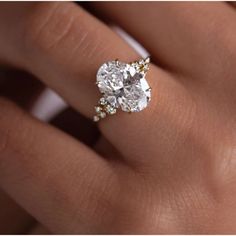 a woman's hand with a diamond ring on her finger and an engagement band