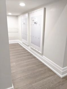 an empty room with white walls and wood flooring is pictured in this image, there are three framed pictures on the wall