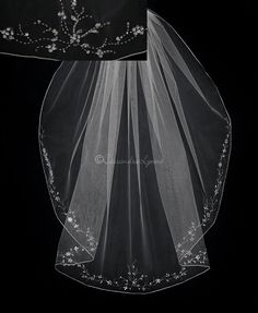 two veils with white flowers on them are shown in black and white photo, one is