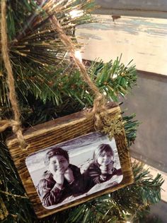 an ornament hanging from a christmas tree with two children on it's back