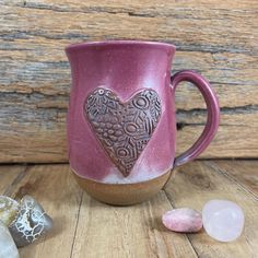 a coffee mug with a heart on it next to some candy canes and rocks