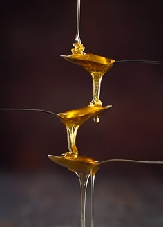 three drops of liquid hanging from a wire